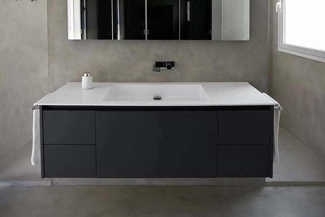 Baño de microcemento con suelo, muros y ducha de color gris.